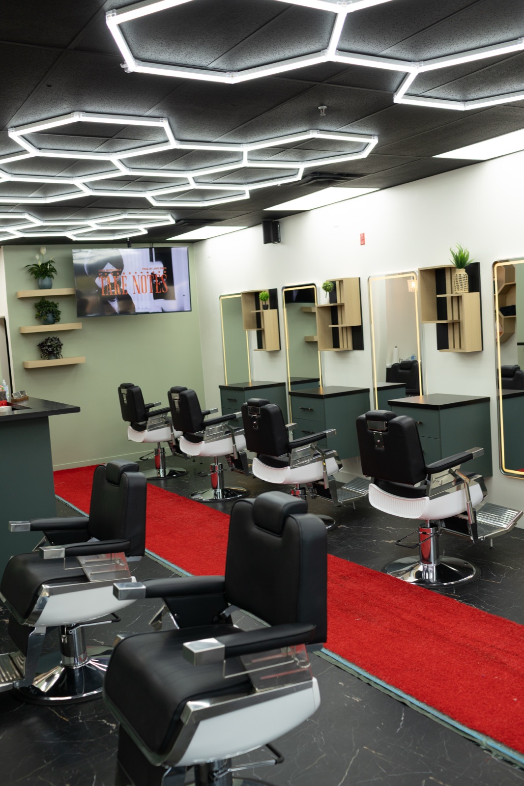 Barber stations and mirrors along the wall at Ezz Cutz