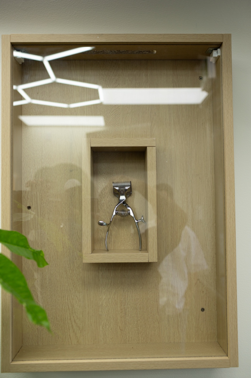 Clippers displayed in a wall-mounted cabinet at Ezz Cutz